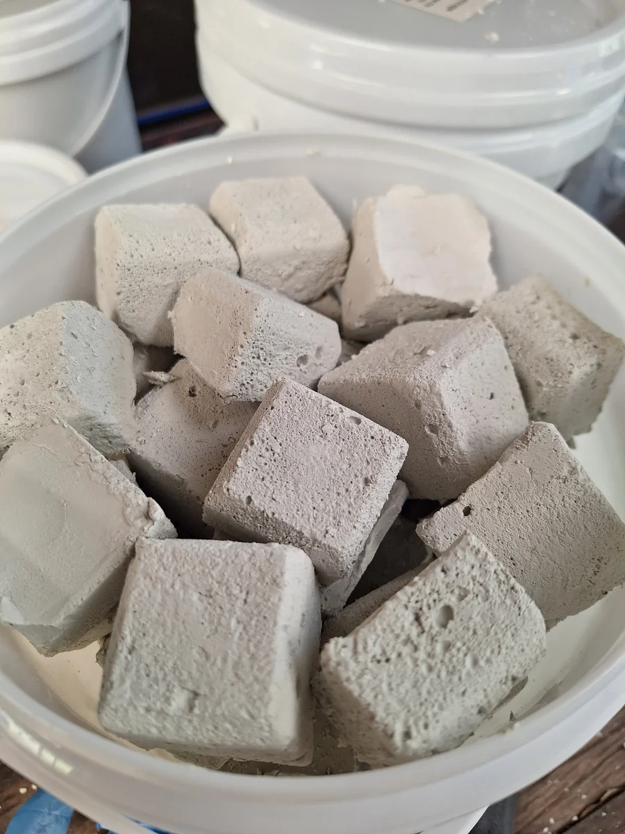 Solid treatment blocks stored in a container